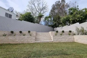 Sandstone retaining full view in a garden wall with plants in a Sydney garden by Ariyania Landscapes, retaining wall installers solutions.