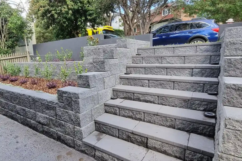 Retaining Wall in Sydney featuring a robust brick design with landscaped tiers, expertly constructed by Arianya, perfect for a DIY cost guide.