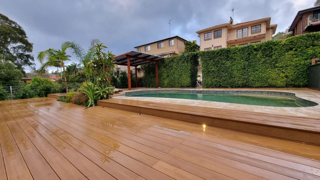 Stylish pool landscaping by Arianya in Sydney, showcasing a sleek pool, timber deck, greenery, and pergola, ideal for modern Sydney backyards.