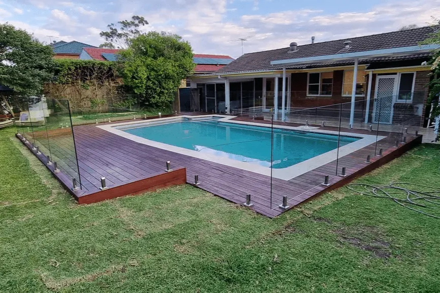 Timber poolside decking with glass fencing, showcasing modern backyard deck ideas for Sydney homes.
